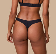 Ally from the back in the No-Show Thong in Black, showcasing the minimal coverage and seamless back design.