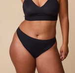India wearing the No-Show Thong in Black, highlighting the smooth, seamless fit on her curves. sizing: India wears size Large
