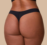 A detailed close-up of the No-Show Thong in Black on India, focusing on the seamless back and second-skin feel.