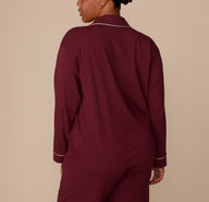 Back view of model Zarria in the Perfect Pima Long Sleeve Pajama Shirt and Pants set in Bordeaux. The image highlights the soft drape and relaxed fit of the fabric.