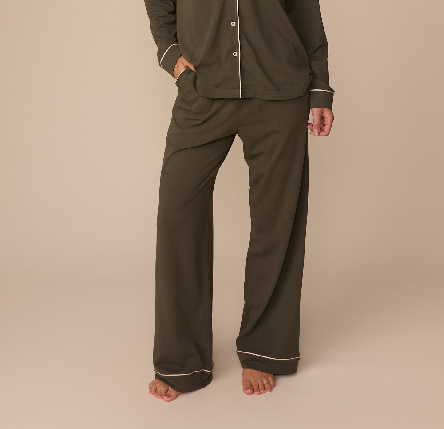Cropped front view of Alexis wearing the Perfect Pima Pajama Pants in Olive with the matching Perfect Pima Long Sleeve Pajama Shirt. The image focuses on the wide-leg cut and contrast piping at the cuffs.