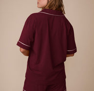 Back view of model Sonnie in the Perfect Pima Pajama Shirt and Shorts in Bordeaux. The image highlights the relaxed fit and smooth drape of the lightweight fabric.