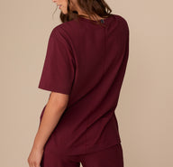 Back view of model Alexis in the Perfect Pima Pajama Tee and Pants in Bordeaux. The tee has a center back seam and a gently curved hem.