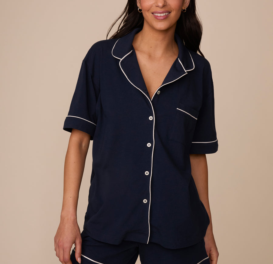 Marcela wears the Perfect Pima Pajama Shirt in Navy, highlighting the relaxed button-down fit with contrast white piping along the collar, placket, sleeves, and chest pocket. sizing: Marcela wears size XS