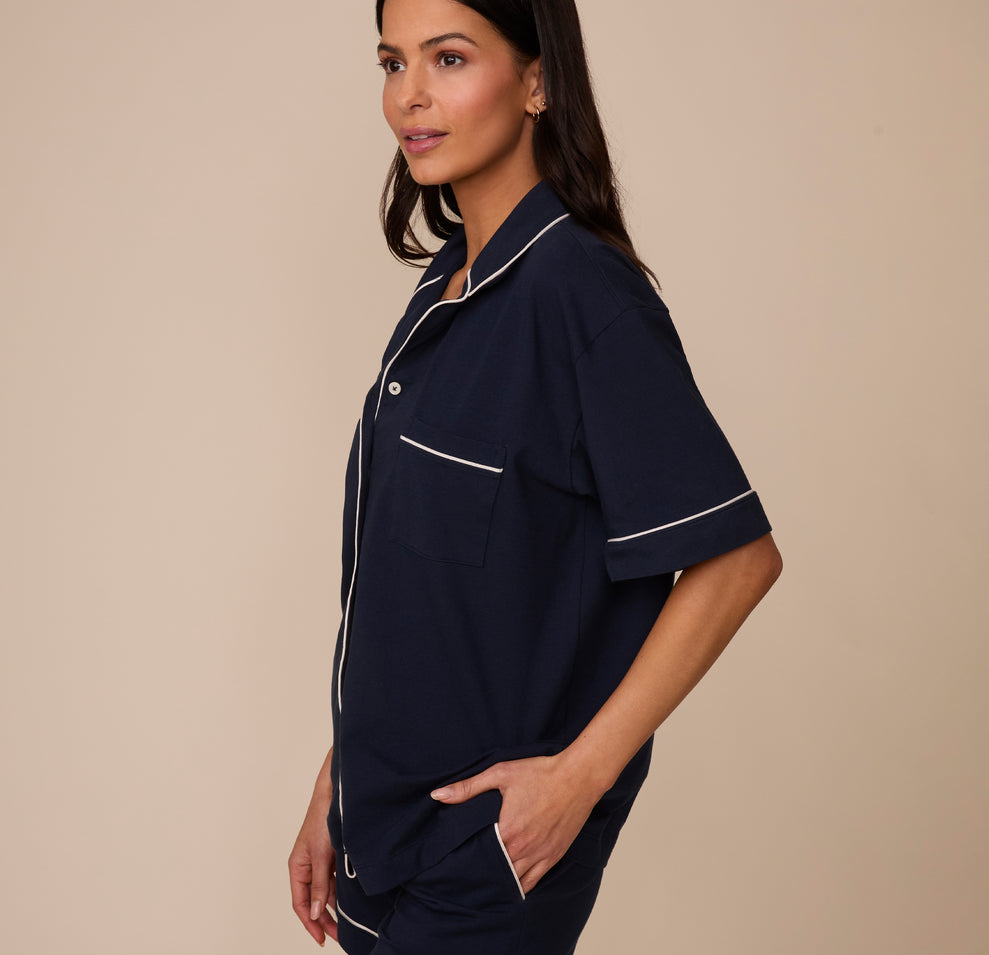 Side profile of Marcela wearing the Perfect Pima Pajama Shirt in Navy with her hand in the matching Perfect Pima Pajama Shorts pocket, emphasizing the casual, comfortable fit.