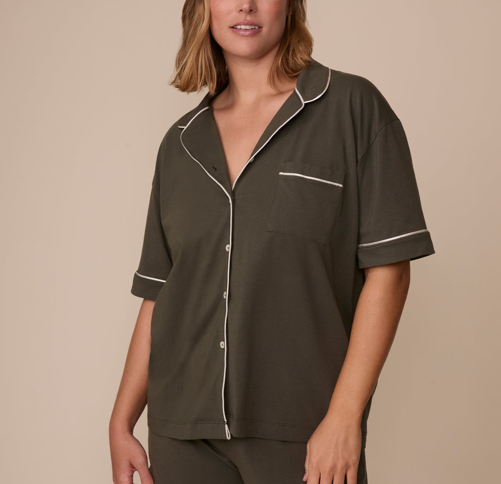 Sonnie wears the Perfect Pima Pajama Shirt in Olive, showing the relaxed button-down front with white piping along the collar, placket, sleeves, and chest pocket. sizing: Sonnie wears size XL
