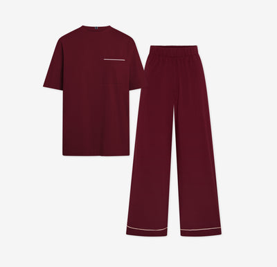 Harper Wilde Pima Pajama Set in Bordeaux. Includes relaxed fit tee with white chest pocket piping and matching long pants. Set laid flat on a white background.
