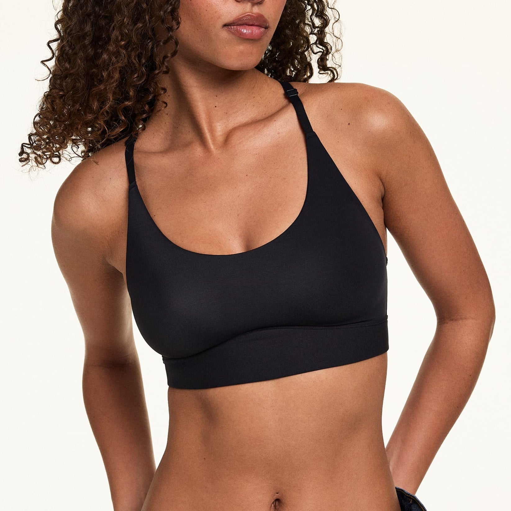 Front view of model wearing the Bliss Racerback Bralette in Black, showing the scoop neckline and adjustable racerback straps.