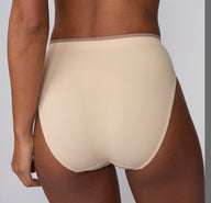 On a light gray studio backdrop, a back view of Courtney wearing the Smooth Seamless underwear in Beige highlights the clean finish and smooth microfiber fabric across the back.