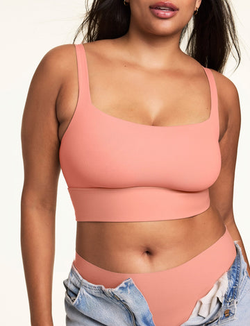 Front view of model wearing the Bliss Squareneck Bralette and matching high-waist underwear in Cabana, with unfastened light wash denim jeans.