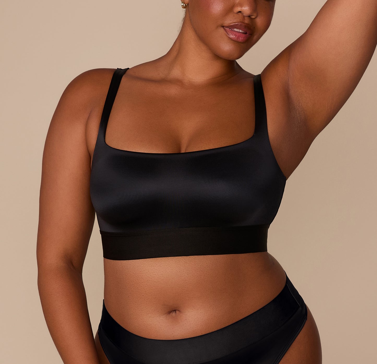 Zarria wearing the Stretch Satin Square Neck Bralette in Black, shown from the front. The image highlights the wide straps, square neckline, and smooth satin fabric. sizing: Zarria wears size XL
