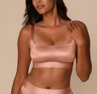 Victoria wearing the Stretch Satin Square Neck Bralette in Champagne, shown from the front. The bralette features a wide square neckline and longline body with a smooth, satiny finish. sizing: Victoria wears size Medium