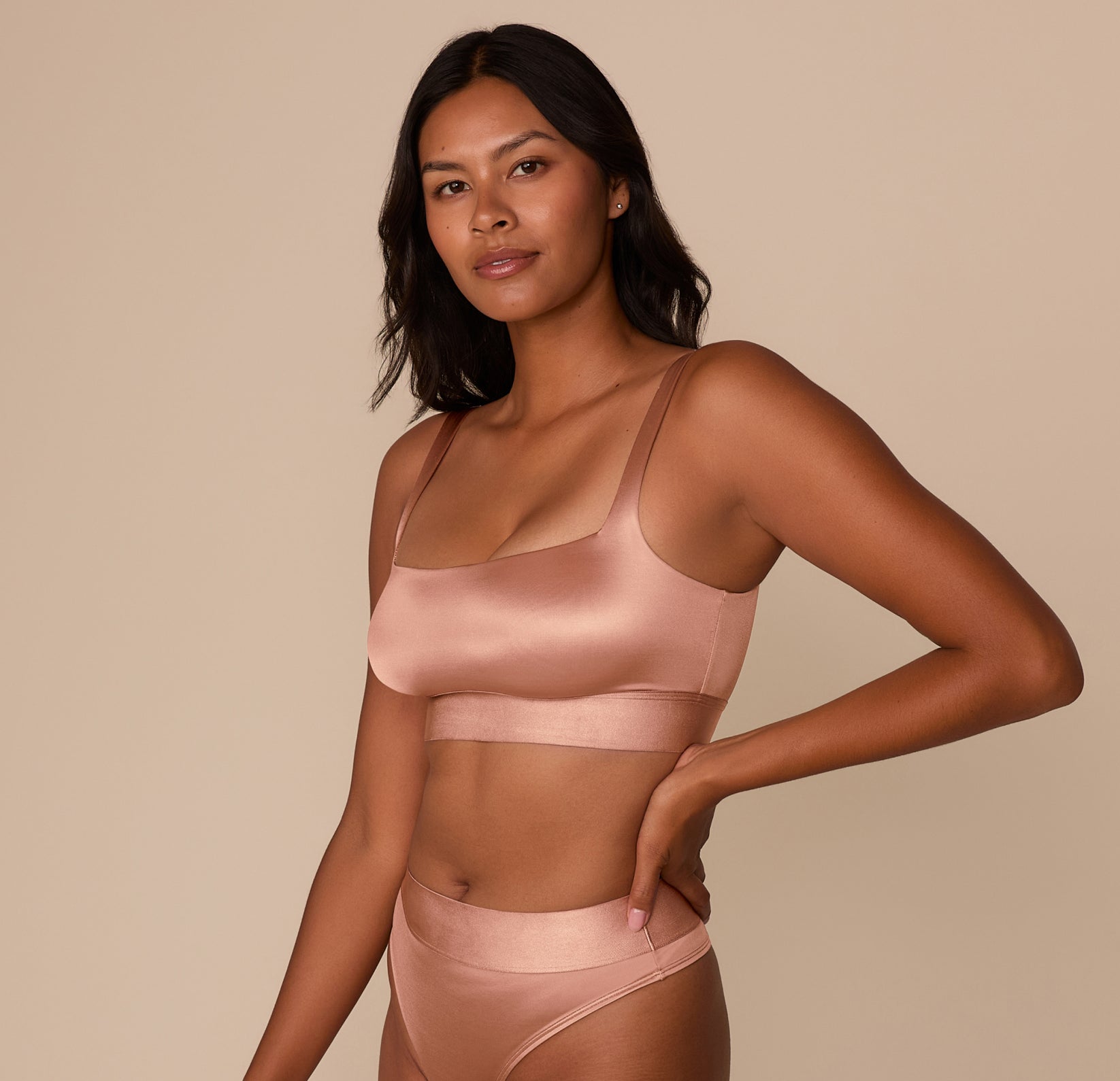 Close-up front view of Victoria smiling in the Stretch Satin Square Neck Bralette in Champagne. The image focuses on the soft sheen and the wide supportive straps.