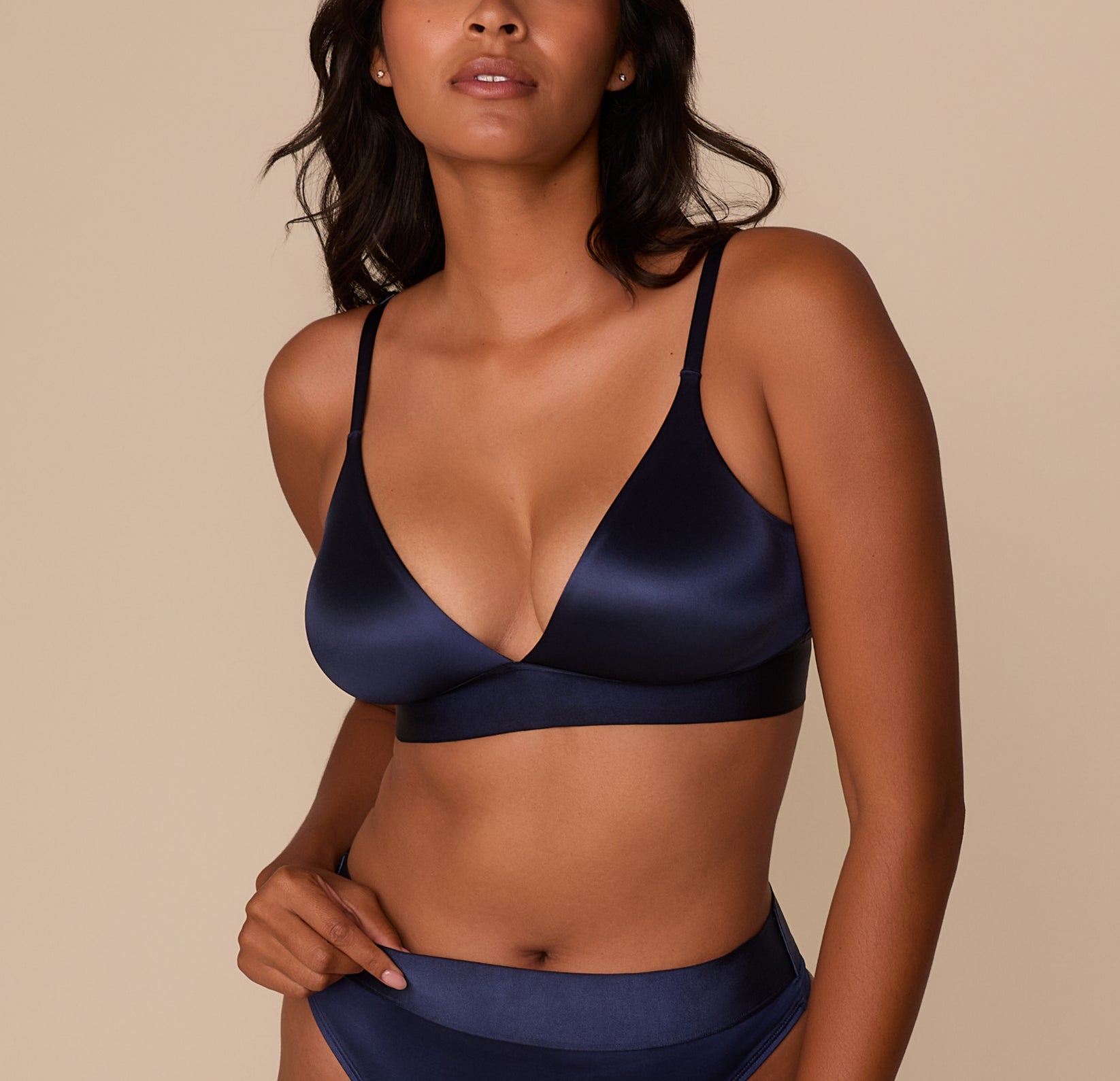 Front view of Victoria wearing the Stretch Satin Triangle Bralette in Navy. The bralette features a plunging V-neckline and wide underband for comfort. sizing: Victoria wears size Medium