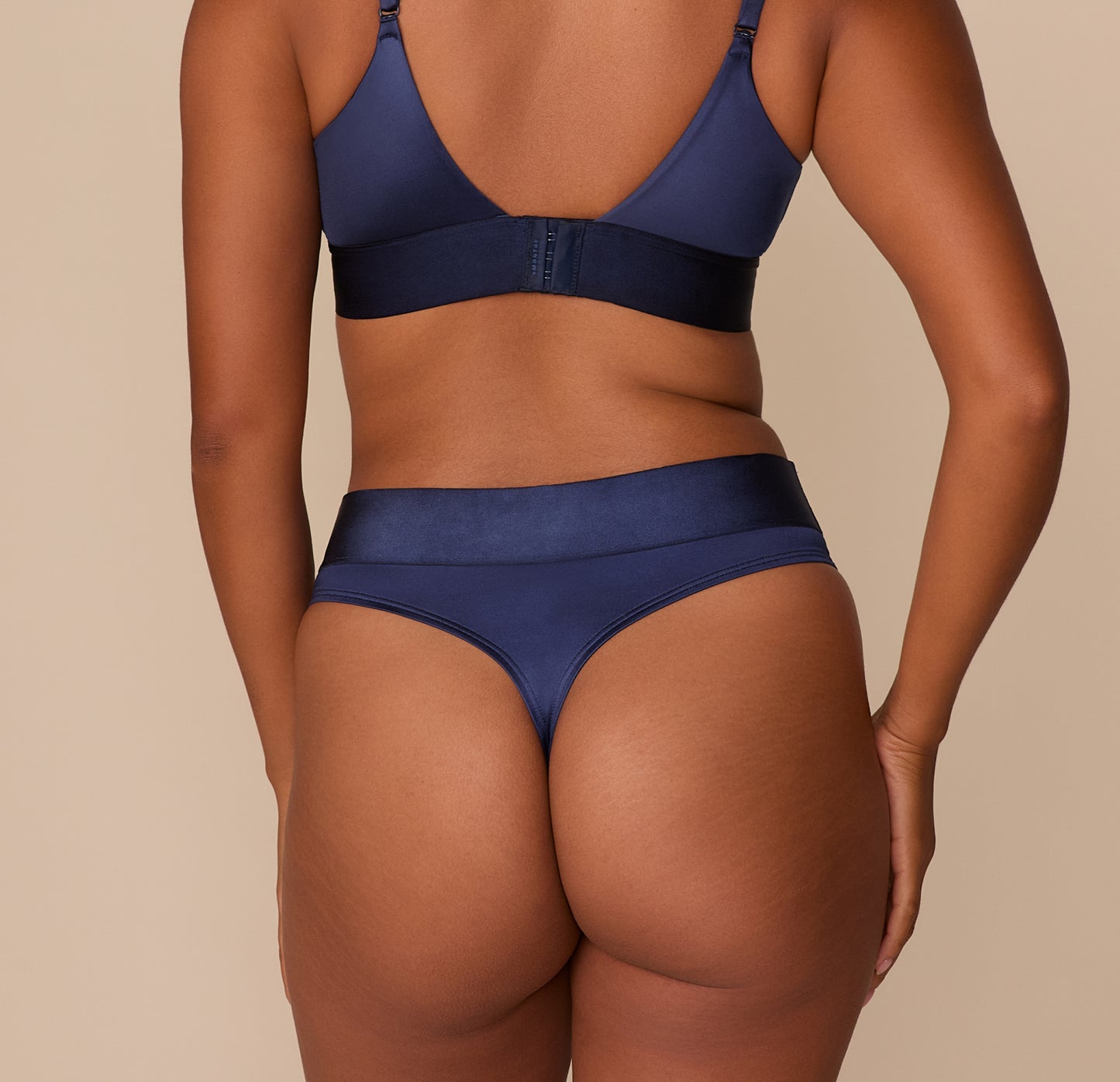 Rear view of the Navy Highwaist Thong, showcasing minimal coverage and smooth satin finish.