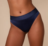 Close-up front view of the Navy thong’s wide waistband and lustrous satin fabric.