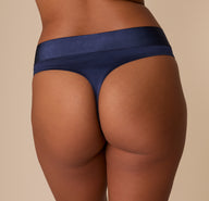 Back close-up of the thong showing curve-hugging fit and seamless lines in Navy satin.