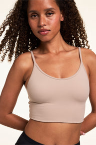 On a light studio backdrop, Courtney wears the Whipped Knit Scoop Bralette in Mushroom with black underwear. The longline bralette features a scoop neckline, slim straps, and smooth knit construction.