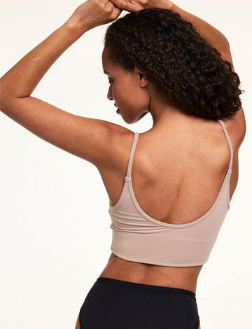 Back view on a light studio backdrop of Courtney wearing the Whipped Knit Scoop Bralette in Mushroom with black underwear. The bralette features adjustable straps, a scoop back, and soft knit fabric.