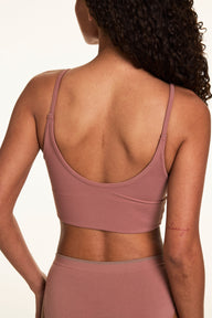 Back view on a light studio backdrop of Courtney wearing the Whipped Knit Scoop Bralette in Plum with matching underwear. The bralette features adjustable straps, a scoop back, and soft knit fabric.