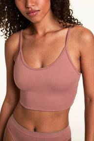 Close-up on a light studio backdrop of Courtney wearing the Whipped Knit Scoop Bralette in Plum with matching underwear. The bralette features a scoop neckline, soft knit fabric, and a smooth longline band. sizing: Courtney wears size Small