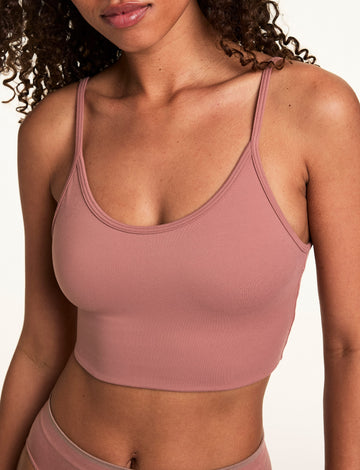 Close-up on a light studio backdrop of Courtney wearing the Whipped Knit Scoop Bralette in Plum with matching underwear. The bralette features a scoop neckline, soft knit fabric, and a smooth longline band. sizing: Courtney wears size Small