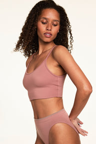 On a light studio backdrop, Courtney wears the Whipped Knit Scoop Bralette in Plum with matching underwear. The bralette features a scoop neckline, thin straps, and a smooth knit finish designed for everyday comfort.