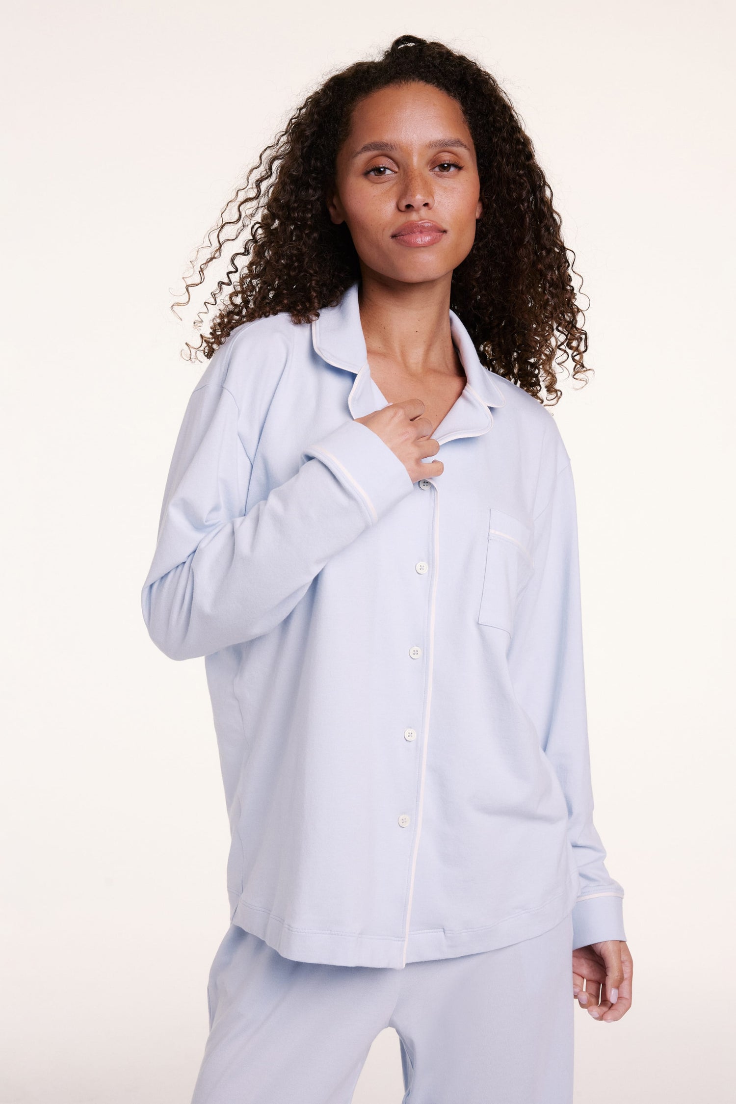 In a studio setting, Courtney wears the Perfect Pima Pajama Long Sleeve Shirt in Soft Blue, featuring a button-front design, chest pocket, and soft, breathable fabric. sizing: Courtney wears size Small