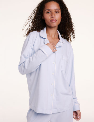 In a studio setting, Courtney wears the Perfect Pima Pajama Long Sleeve Shirt in Soft Blue, featuring a button-front design, chest pocket, and soft, breathable fabric. sizing: Courtney wears size Small