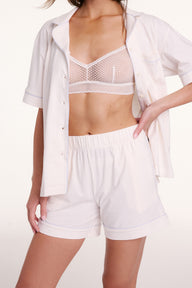 On a light studio backdrop, Gianna wears the Perfect Pima Pajama Shorts in Ivory with the matching button-down worn open, highlighting the elastic waistband and lightweight fabric. sizing: Gianna wears size Small