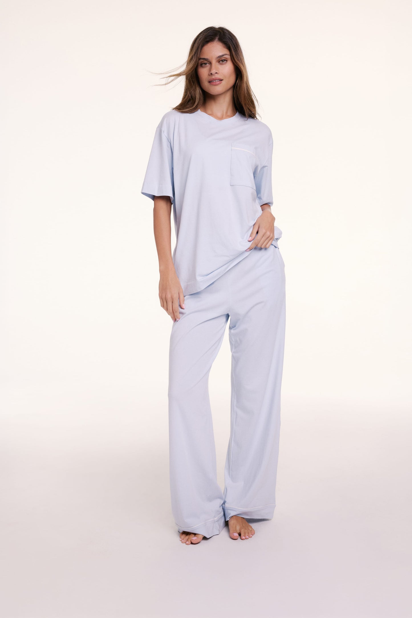 In a studio setting, Linni wears the Perfect Pima Pajama Tee in Soft Blue with matching pants, featuring a relaxed fit, crew neckline, and short sleeves.