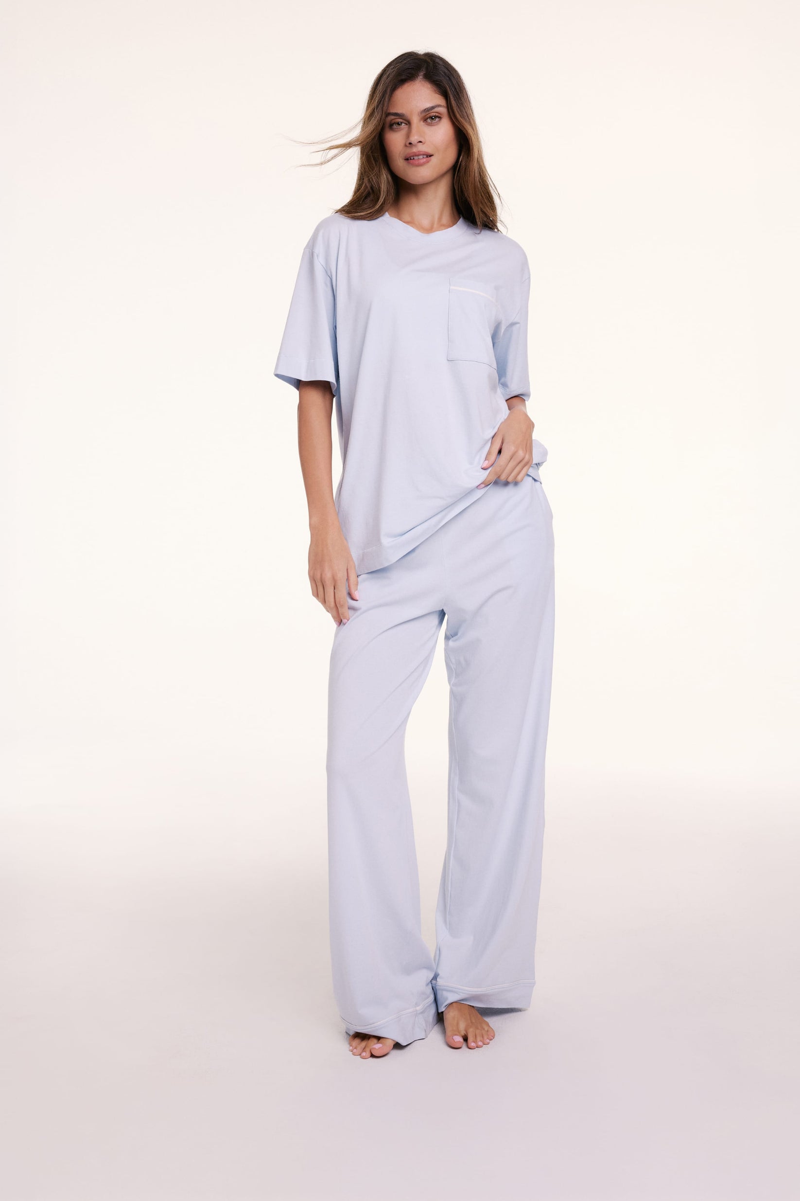 In a studio setting, Linni wears the Perfect Pima Pajama Tee in Soft Blue with matching pants, featuring a relaxed fit, crew neckline, and short sleeves.