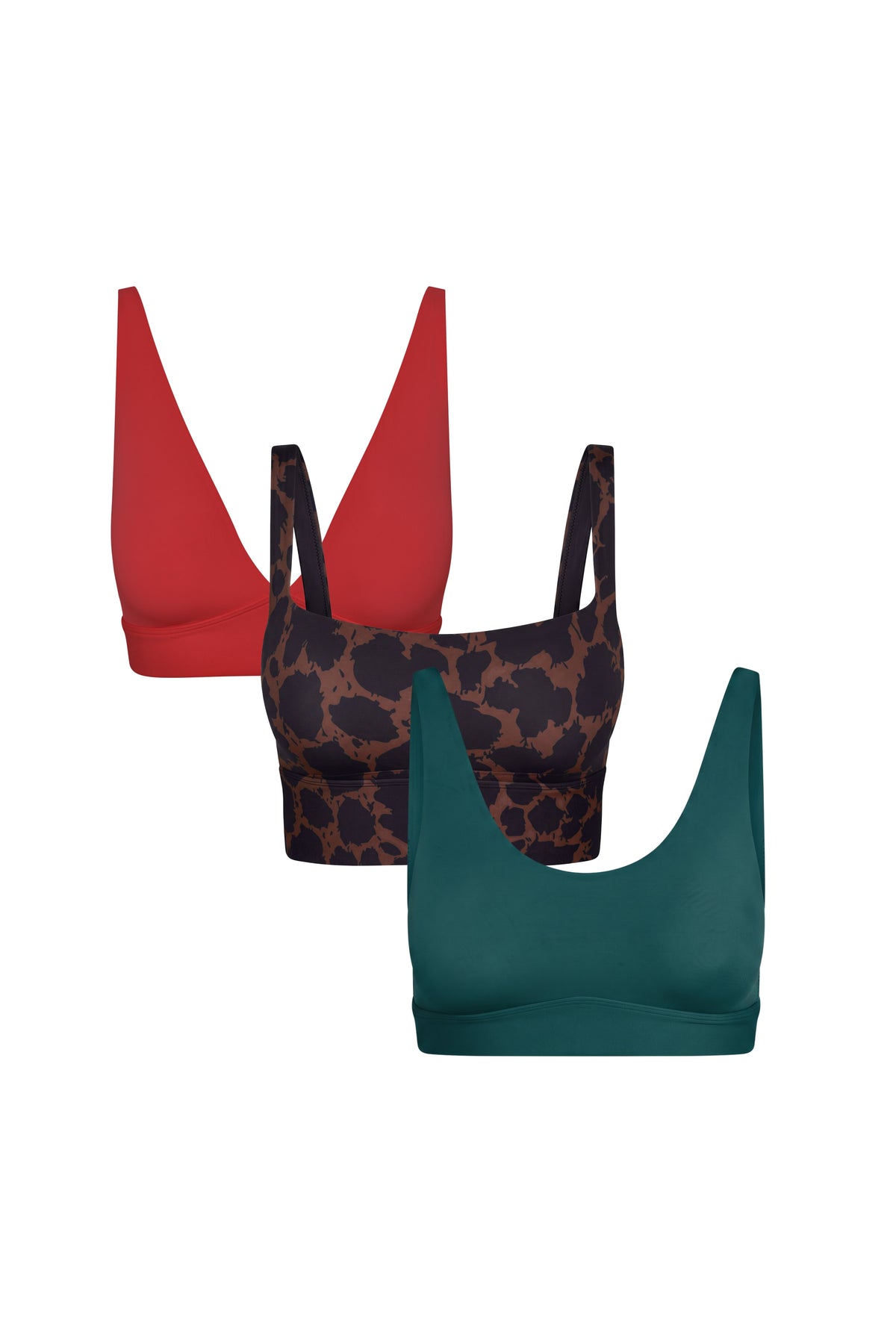 Flat lay of the Blissmas Gift Bundle featuring three bralettes in Cherry Red, Leopard Print, and Teal, shown in a ghost lay arrangement.