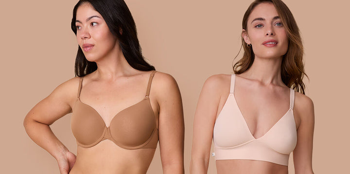 Two models stand against a neutral beige background. The model on the left wears the Base T-Shirt Bra in Tan, and the model on the right wears the Bliss Triangle Bralette in Rose. The image highlights supportive yet minimalist silhouettes in warm neutral shades.