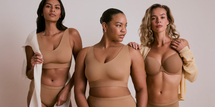 Three models wearing Harper Wilde intimates in tan: two in the Bliss Bralette and one in the Base T-Shirt Bra