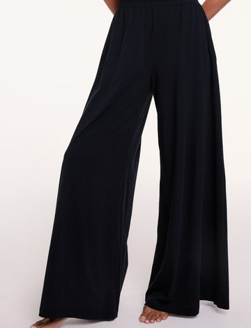 In a studio setting, Courtney wears the Sunday Pima Pant in Black, highlighting the elastic waistband and fluid, wide-leg silhouette. sizing: Linni wears size Small