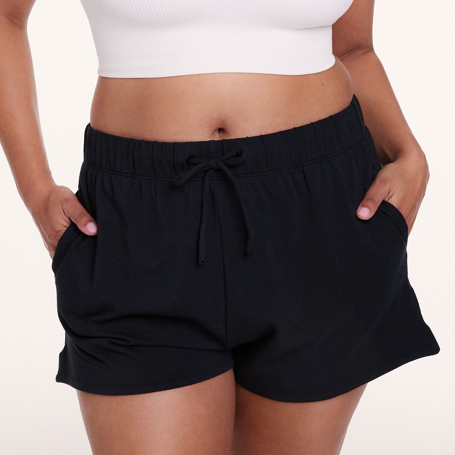 Ona white studio backdrop, Alana wears the Sunday Pima Short in Black, highlighting the elastic waistband, adjustable drawstring, and soft, lightweight fabric.