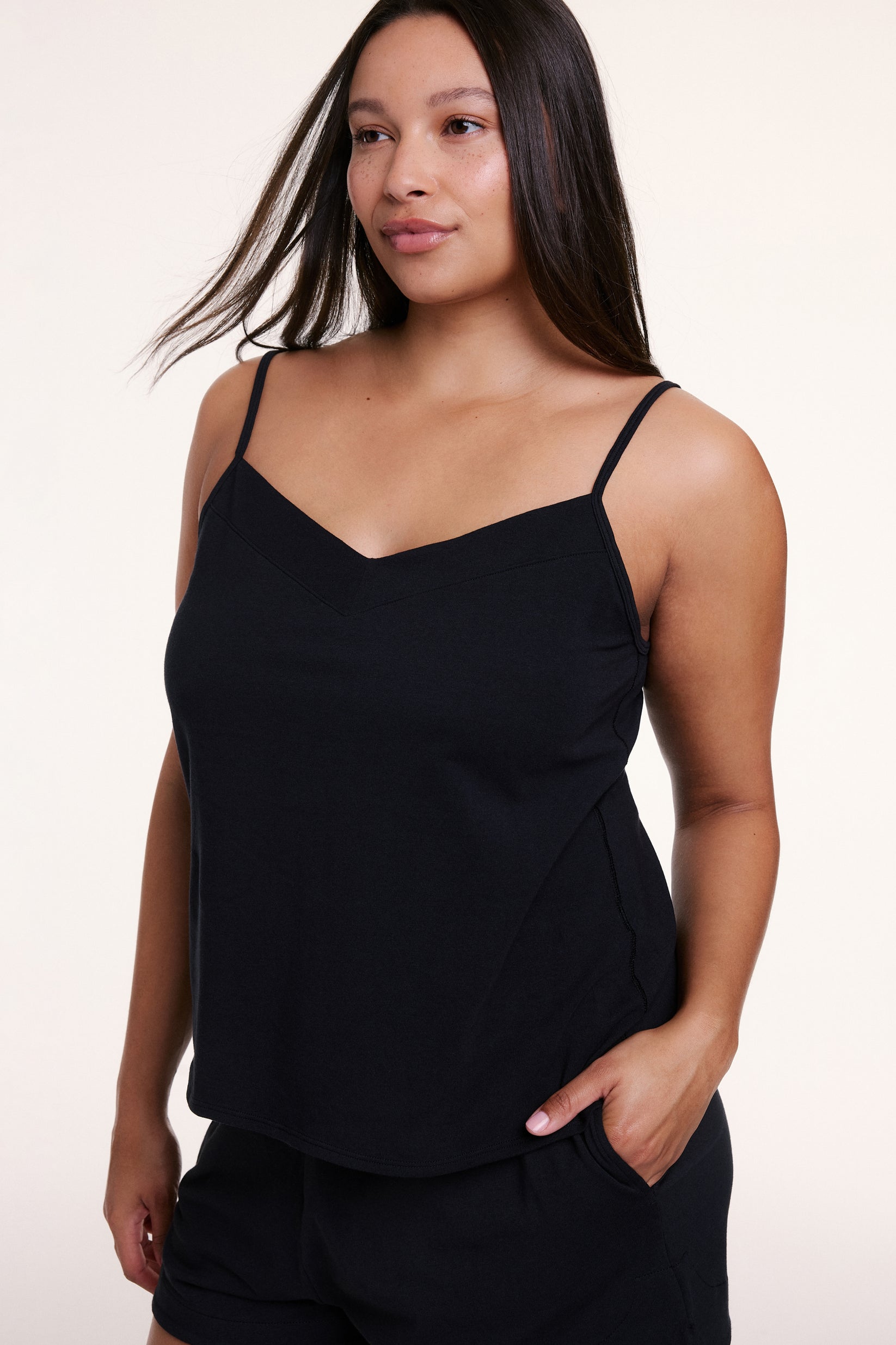 In a studio setting, Alana wears the Sunday Pima Tank in Black, showing the soft fabric, thin straps, and relaxed fit. sizing: Alana wears size Large