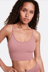 In a studio setting, Courtney wears the Whipped Knit Scoop Bralette in Plum, shown from the front with a scoop neckline and thin adjustable straps. The soft, stretchy fabric provides lightweight, wireless comfort with a smooth, longline fit.