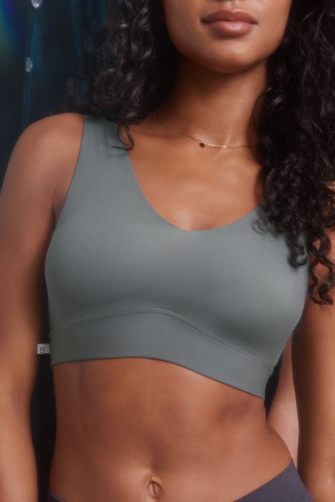 Model Ally wearing the Bliss Bralette in Stone. The close-up emphasizes the smooth, supportive fit and the soft, neutral gray-green tone of the bralette.