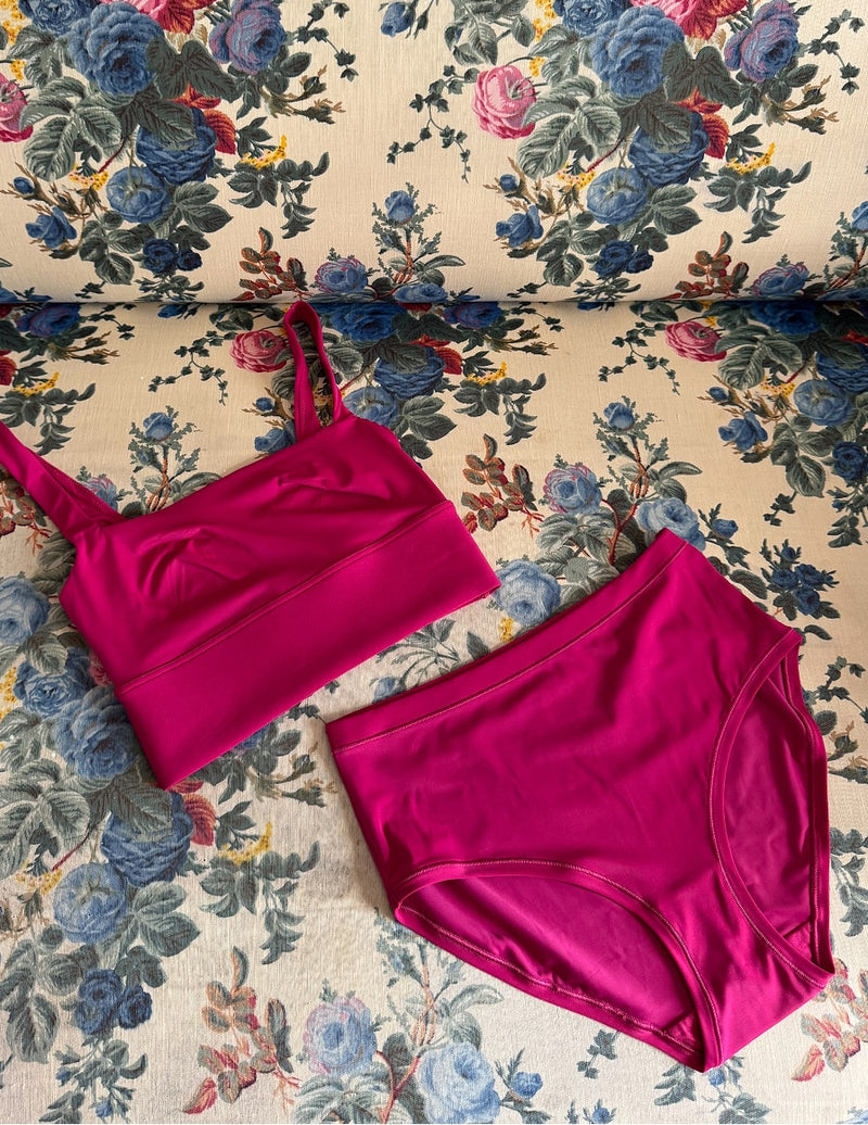 The Bliss Square Neck Bralette and High-Waist Brief in Winterberry laid flat on a floral print fabric.