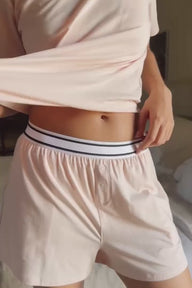 Close up video of a model wearing the Cloud Cotton Pajama Shirt and Retro Boxer in the color Dogwood.