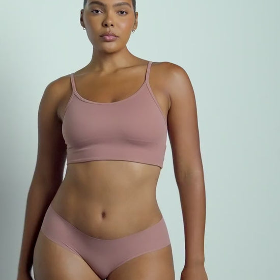 Lifestyle video of model wearing the WhippedKnit Scoop Bralette in Plum — a wire-free bralette with a soft knit texture and wide scoop neckline — paired with the No-Show Hiphugger in Plum, showing the set in motion
