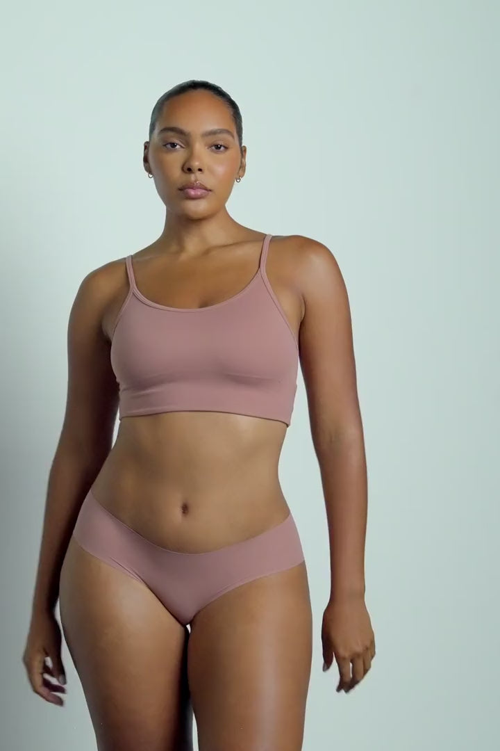 Lifestyle video of model wearing the WhippedKnit Scoop Bralette in Plum — a wire-free bralette with a soft knit texture and wide scoop neckline — paired with the No-Show Hiphugger in Plum, showing the set in motion