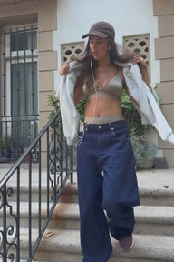 Lifestyle video of model wearing the Stretch Satin Triangle Bralette in Sable — a sleek triangle bralette in lustrous stretch satin fabric with thin adjustable straps — paired with the Stretch Satin Highwaist Thong in Sable, paired with Jeans and a sweatshirt.
