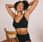 Woman wearing the Cloud Cotton Triangle Bralette in the color Black sizing: Zoe wears size Small