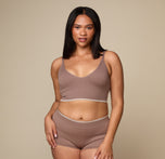 Woman wearing the Lounge Triangle Bralette in the color Oyster sizing: Alexandra wears size Large